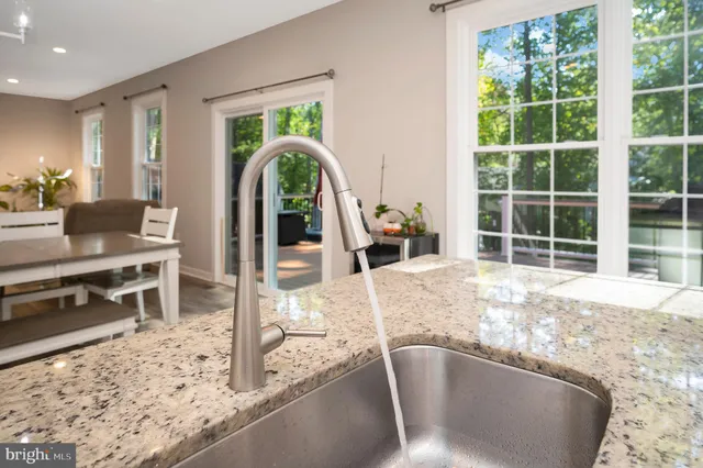 a kitchen with kitchen island wooden floors appliances and cabinets