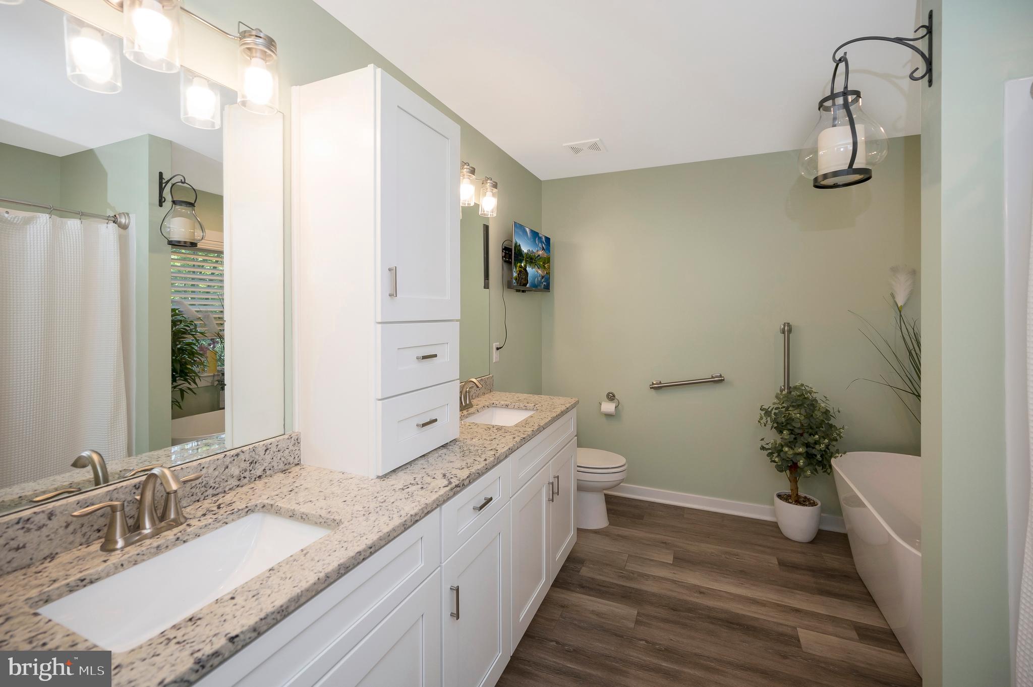112 Butler Circle Locust Grove, VA 22508 - Photo 23 of 57 a spacious bathroom with a granite countertop sink a mirror a vanity and a bathtub
