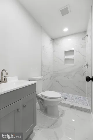 a bathroom with a sink a toilet and mirror