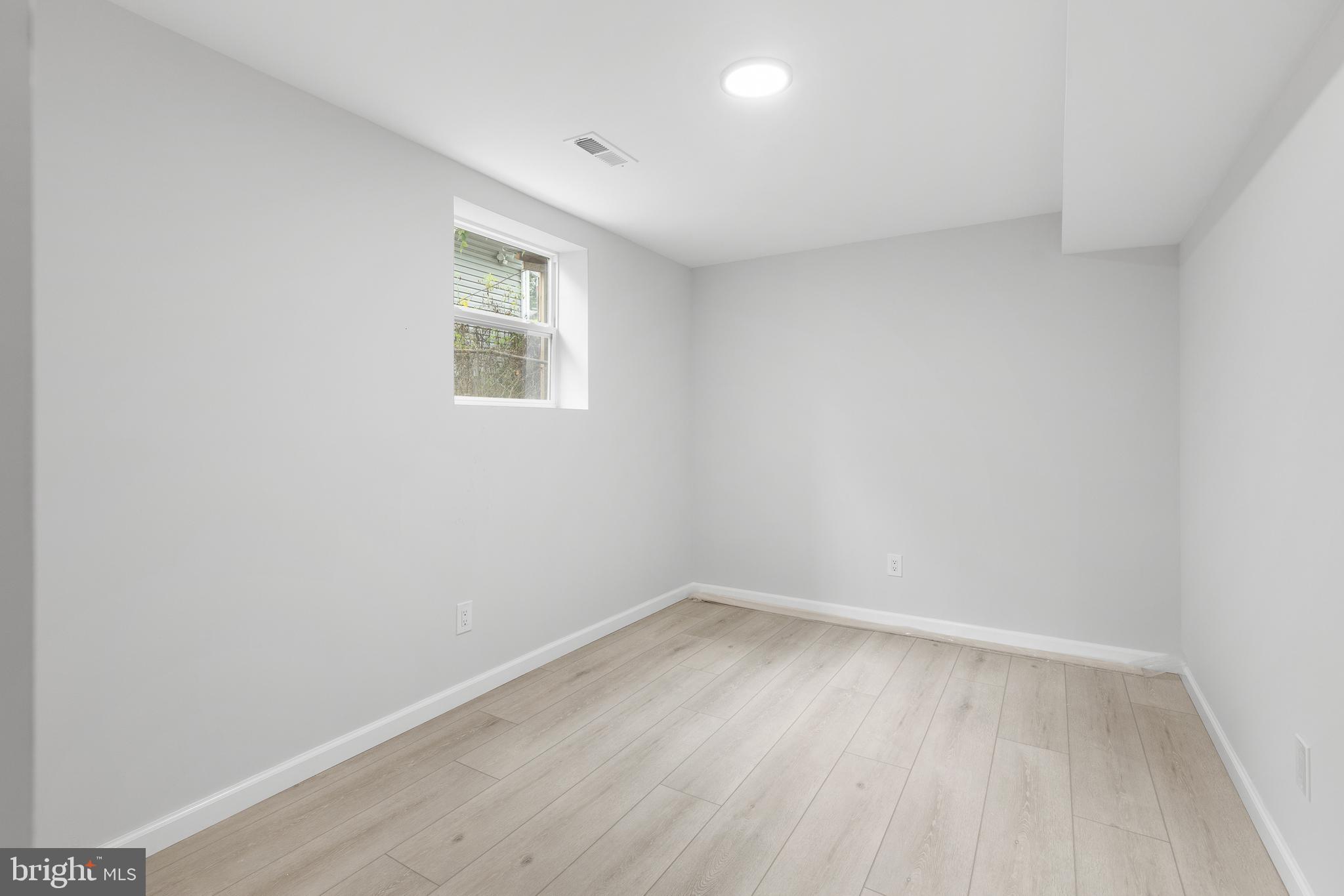 1528 Hunt Avenue Landover, MD 20785 - Photo 24 of 27 a view of an empty room with wooden floor and a window
