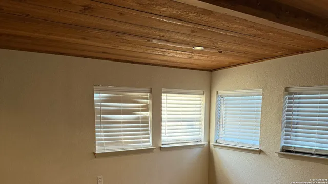 a view of a livingroom with wooden floor a ceiling fan and window