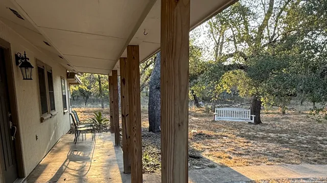 a view of a porch with wooden floor and furniture