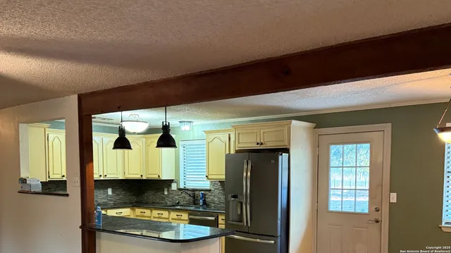 a kitchen with granite countertop white cabinets and wooden floor