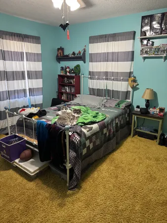 a bed sitting in a bedroom next to a window