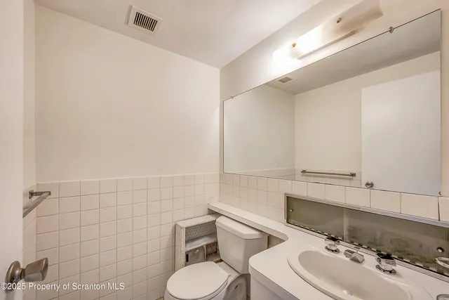 a bathroom with a sink mirror and toilet