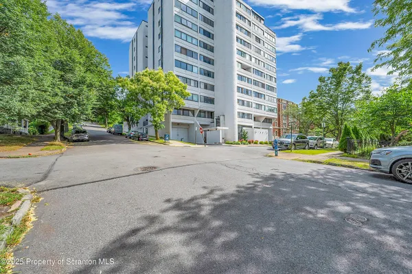 a view of building with cars parked in front of it