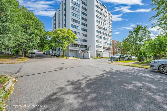 a view of building with cars parked in front of it