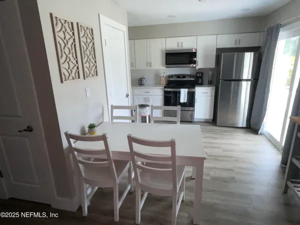a dining room with furniture and kitchen view