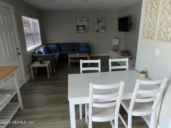 a dining room with furniture and wooden floor