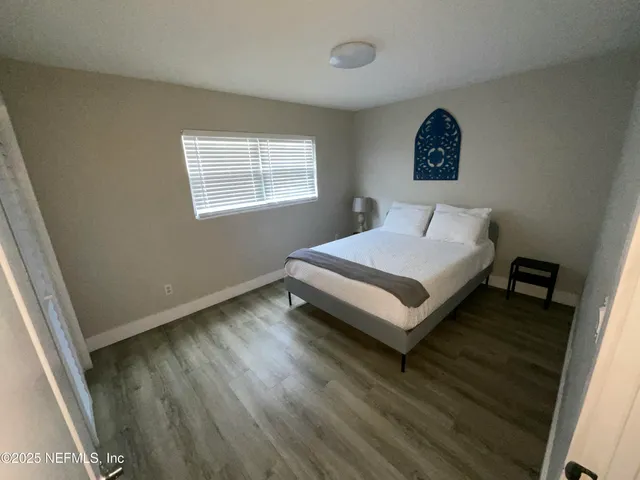 a bedroom with a bed and a large window