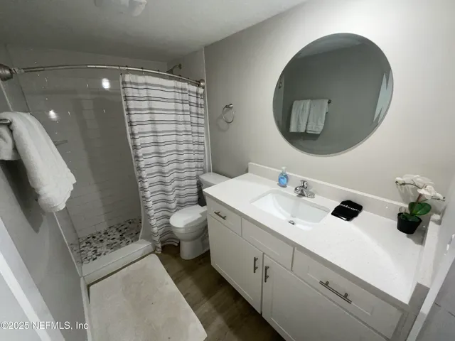 a bathroom with a sink a toilet and shower curtain