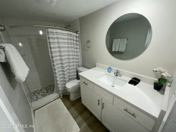 a bathroom with a sink a toilet and shower