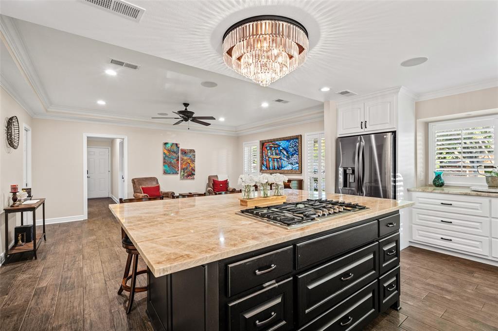 400 Hunters Ridge Circle Coppell, TX 75019 - Photo 6 of 35 a kitchen that has a stove a kitchen island a table and chairs in it