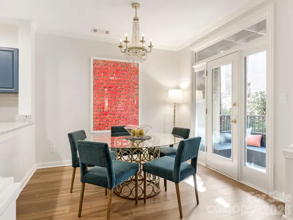 a dining room with furniture a chandelier and wooden floor