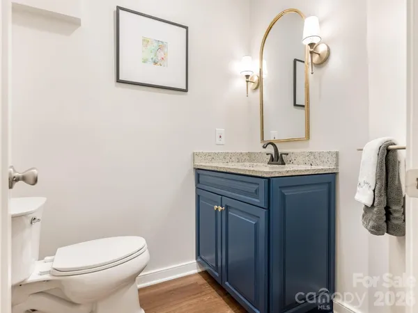 a bathroom with a granite countertop sink toilet and mirror
