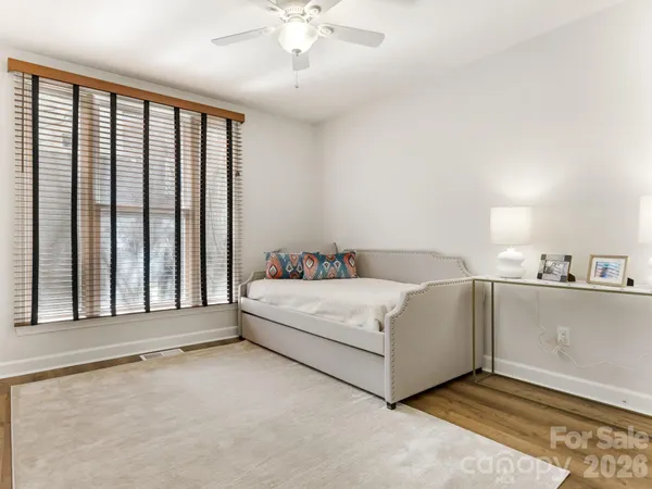 a white bed sitting in a room next to a balcony