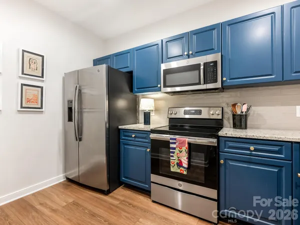 a kitchen with stainless steel appliances granite countertop a refrigerator microwave and sink