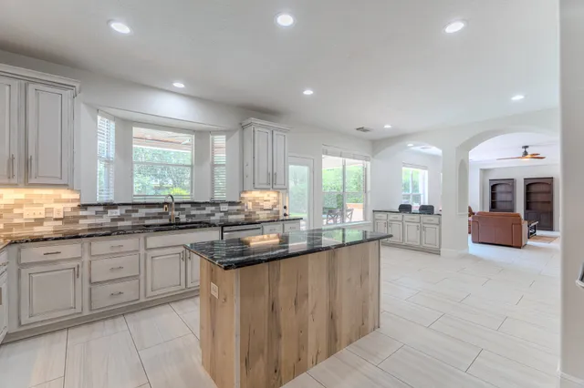 a kitchen with counter top space sink and living room