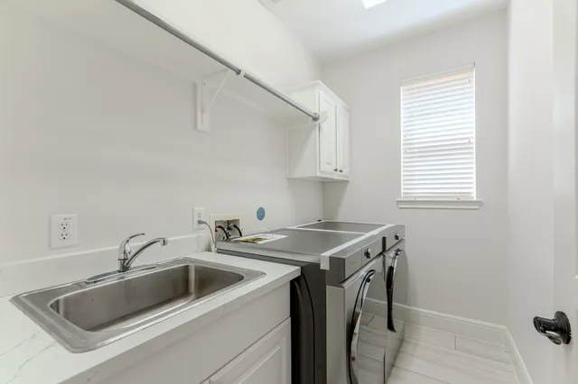 a utility room with sink dryer and washer