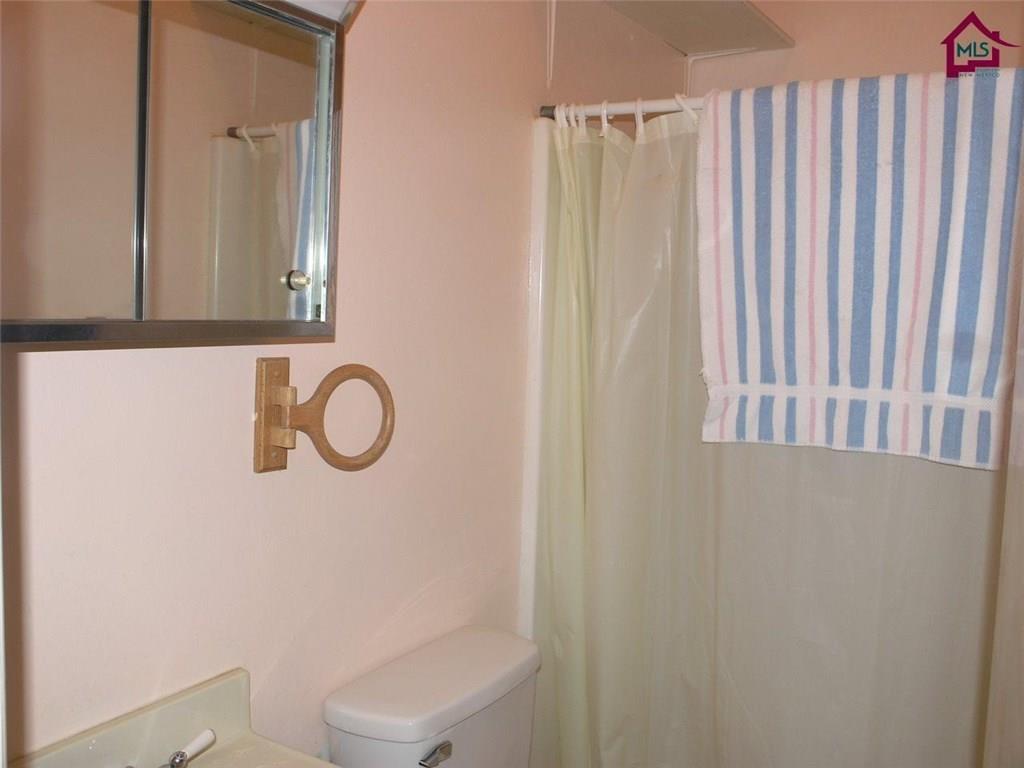 736 Upham Road Elephant Butte, NM 87935 - Photo 15 of 27 a bathroom with a toilet a sink and a window