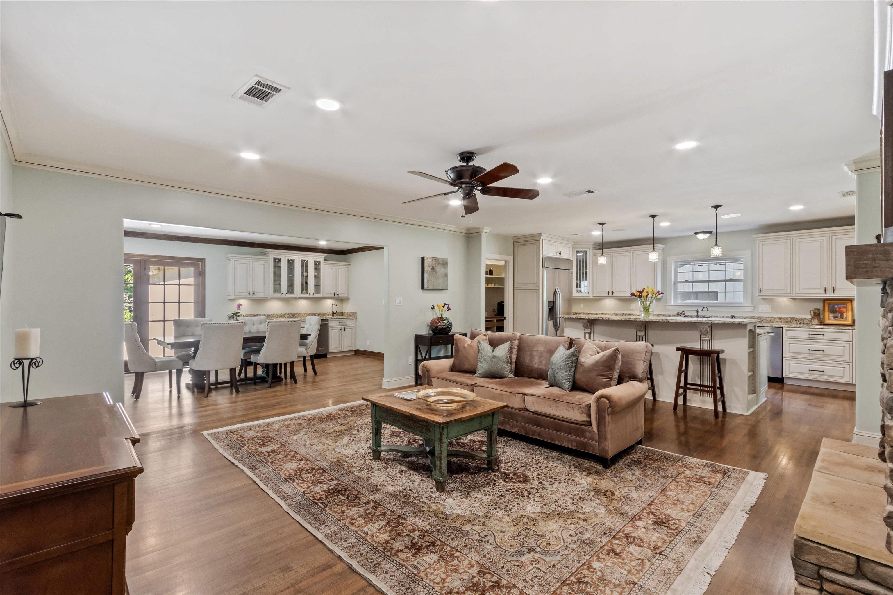 5302 South Angela Road Memphis, TN 38120 - Photo 7 of 40 Open-concept living area featuring wood-finish flooring, recessed lighting, and a prominent stone-clad fireplace