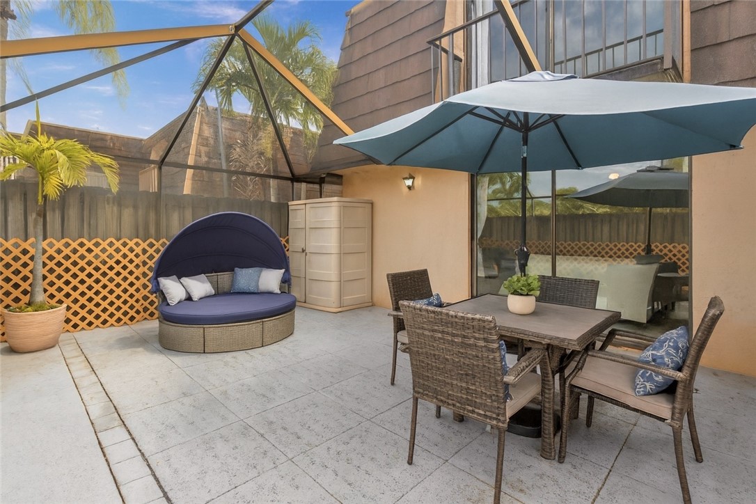 465 East Waverly Place, Unit 8B Vero Beach, FL 32960 - Photo 21 of 28 a patio table and chairs under an umbrella