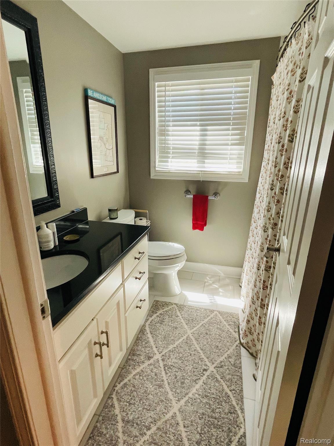 488 Welch Road Northville, MI 48167 - Photo 14 of 22 Bathroom featuring a white vanity with black countertop, integrated sink, and bronze cabinet hardware