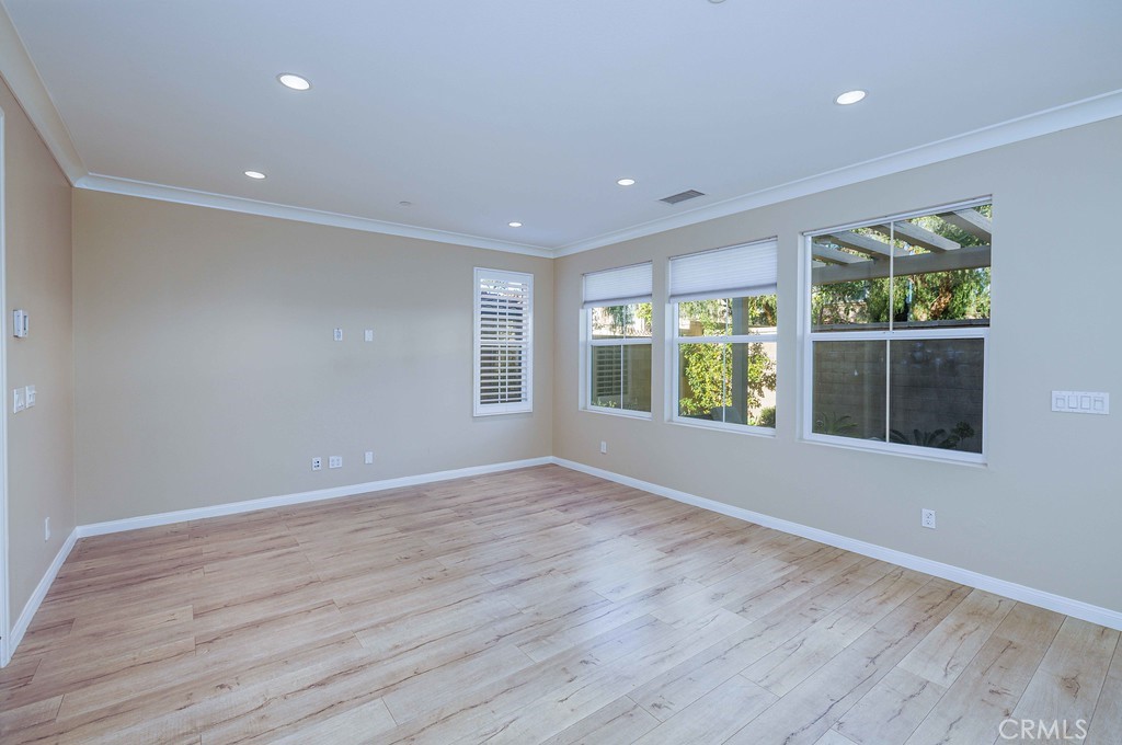 125 Waterleaf Irvine, CA 92620 - Photo 11 of 20 a view of an empty room with wooden floor and a window