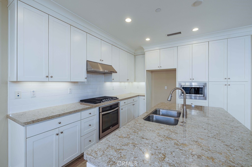 125 Waterleaf Irvine, CA 92620 - Photo 12 of 20 a kitchen with granite countertop white cabinets and stainless steel appliances