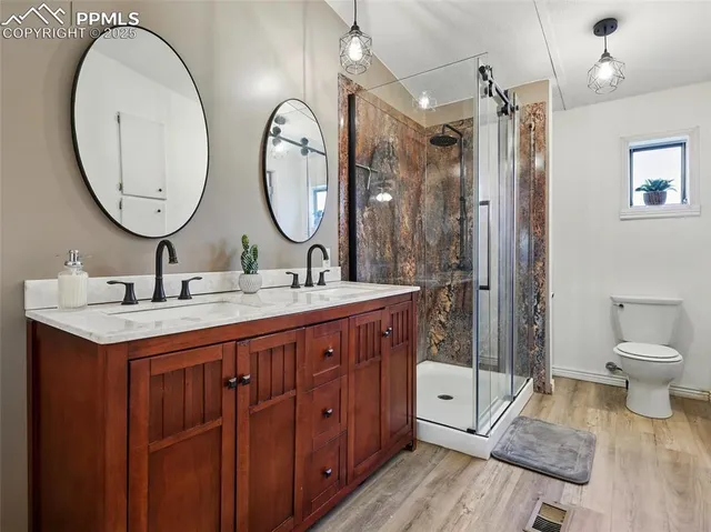 a spacious bathroom with a double vanity sink a toilet and a mirror