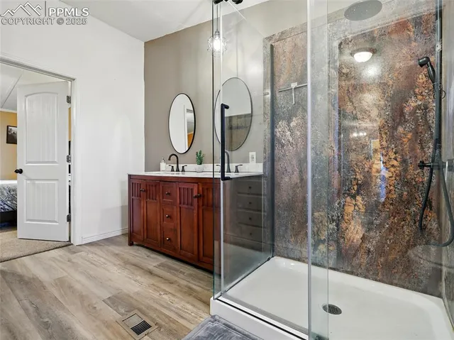 a bathroom with a granite countertop sink a mirror and shower