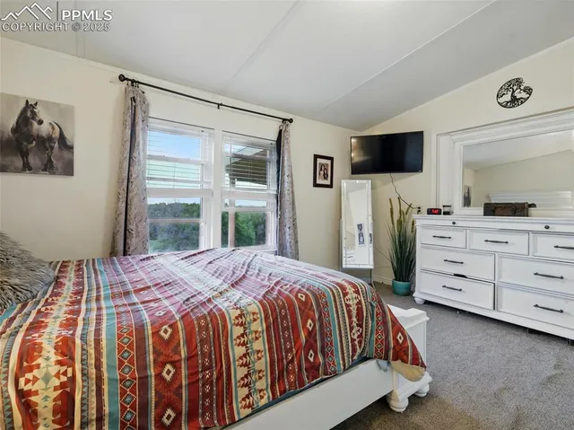 a bedroom with a bed and a flat tv screen in it