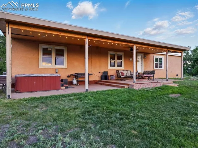 a backyard of a house with table and chairs