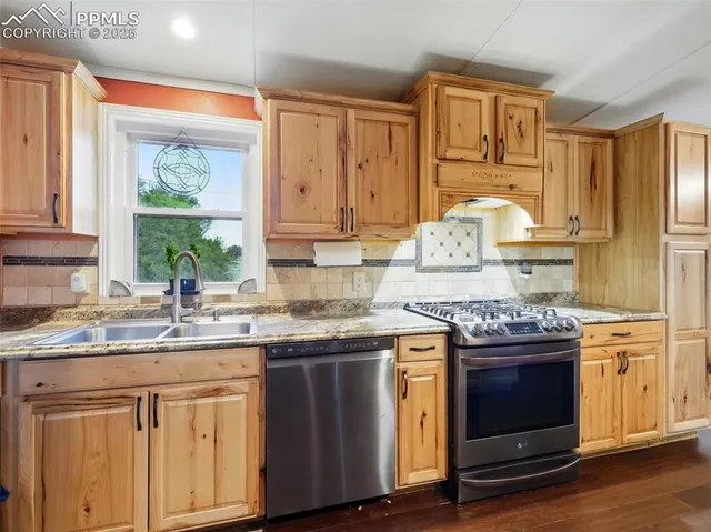 a kitchen with stainless steel appliances granite countertop a stove and cabinets