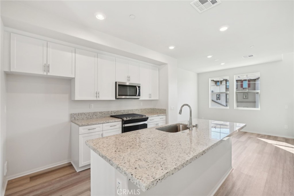 28022 Melrose Drive Temecula, CA 92591 - Photo 14 of 35 a kitchen with stainless steel appliances granite countertop a sink stove and microwave