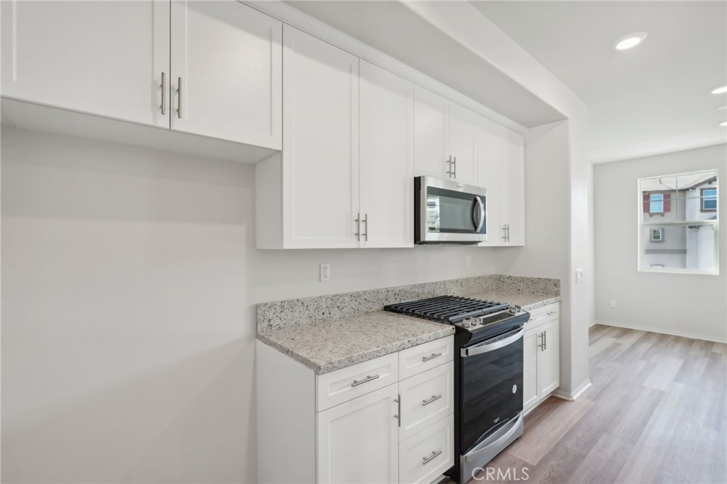 28022 Melrose Drive Temecula, CA 92591 - Photo 15 of 35 a kitchen with granite countertop white cabinets and black appliances