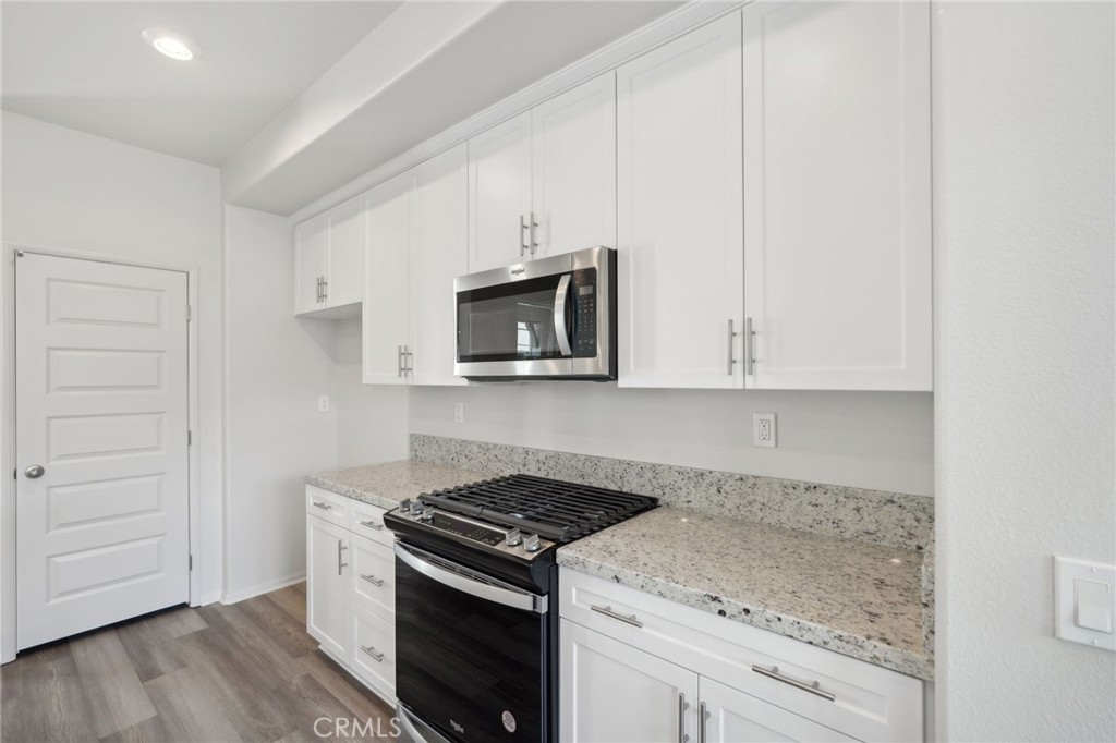28022 Melrose Drive Temecula, CA 92591 - Photo 16 of 35 a kitchen with granite countertop cabinets stainless steel appliances and wooden floor