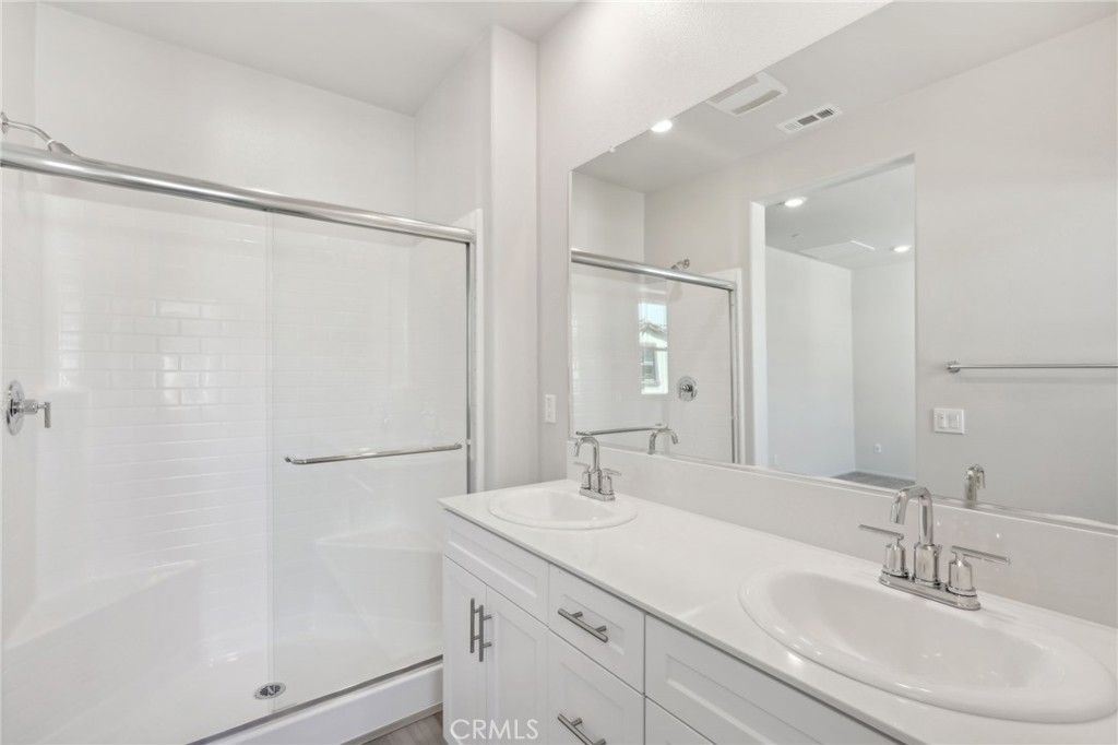 28022 Melrose Drive Temecula, CA 92591 - Photo 29 of 35 a bathroom with a double vanity sink and mirror