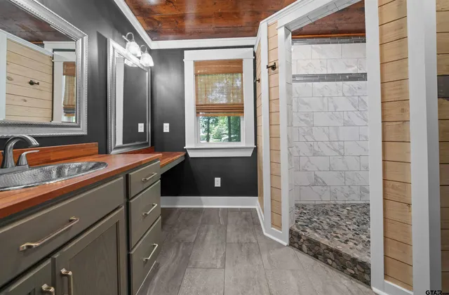 a bathroom with a sink a large mirror and a window