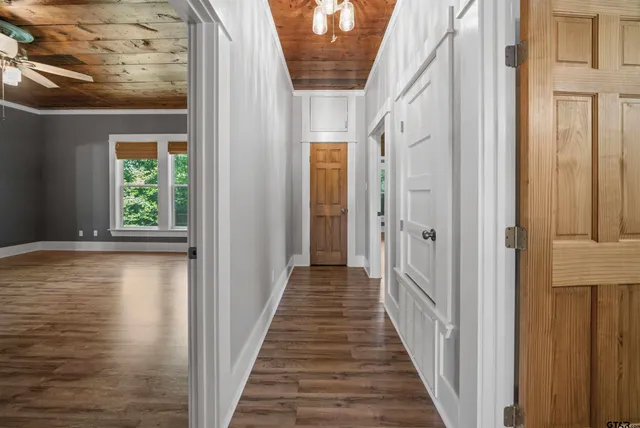a view of empty room with wooden floor and fan