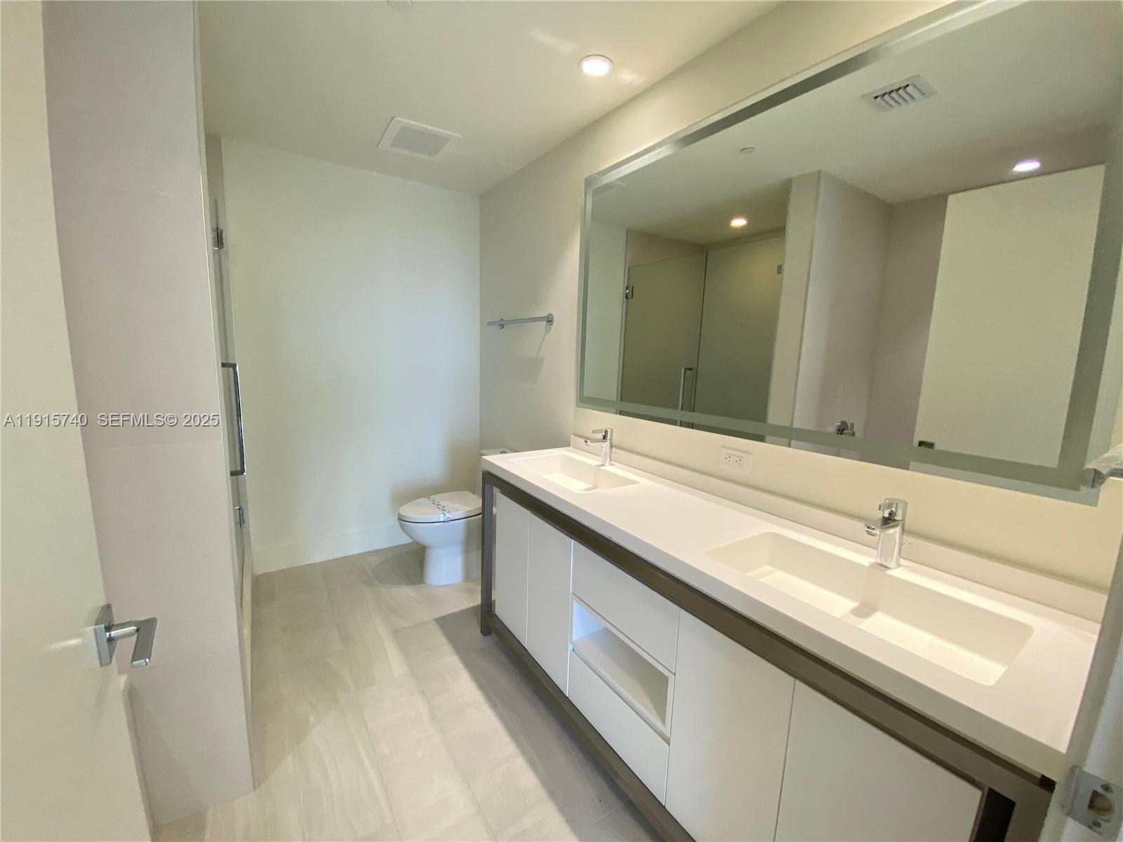 2000 Metropica Way, Unit 2104 Sunrise, FL 33323 - Photo 11 of 62 a bathroom with a sink and a mirror