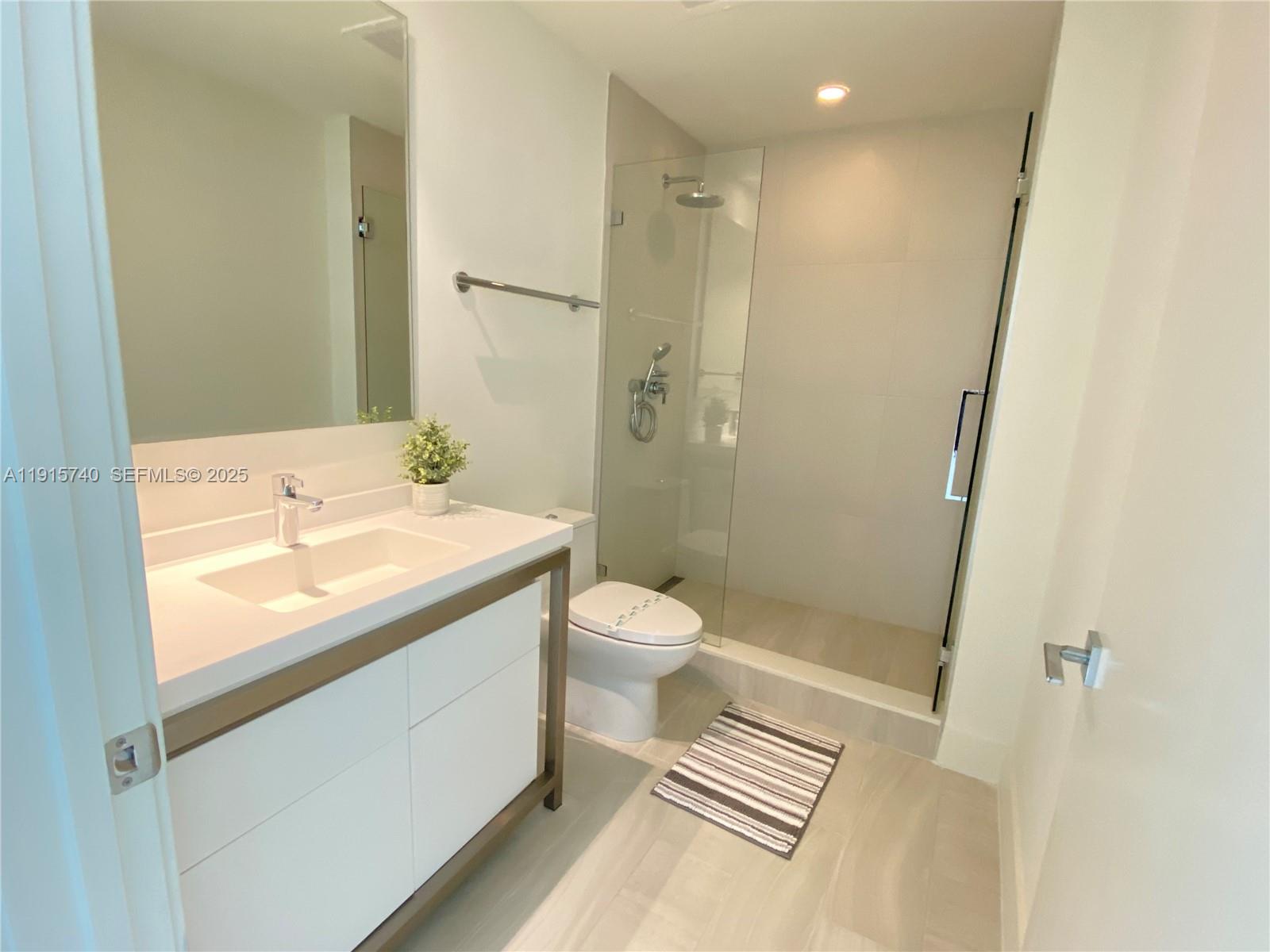 2000 Metropica Way, Unit 2104 Sunrise, FL 33323 - Photo 12 of 62 a bathroom with a sink a toilet and shower