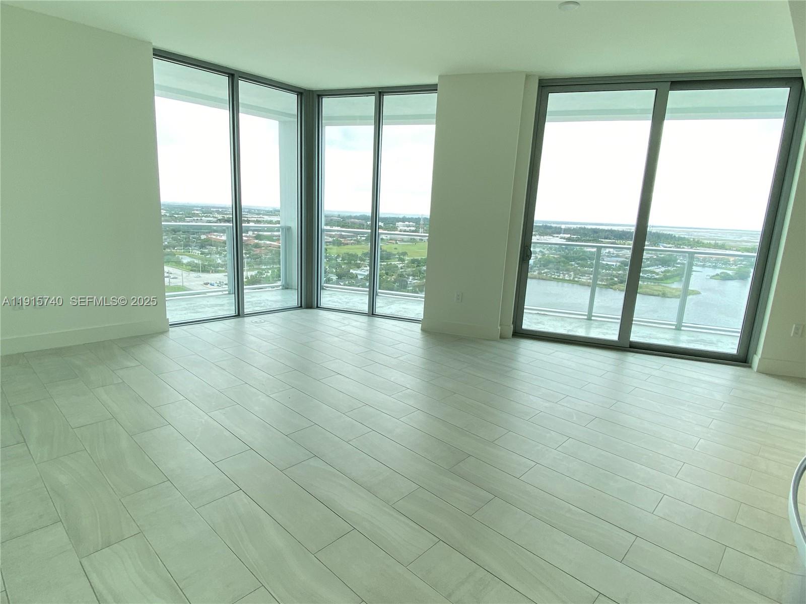 2000 Metropica Way, Unit 2104 Sunrise, FL 33323 - Photo 5 of 62 a view of an empty room with wooden floor and a window