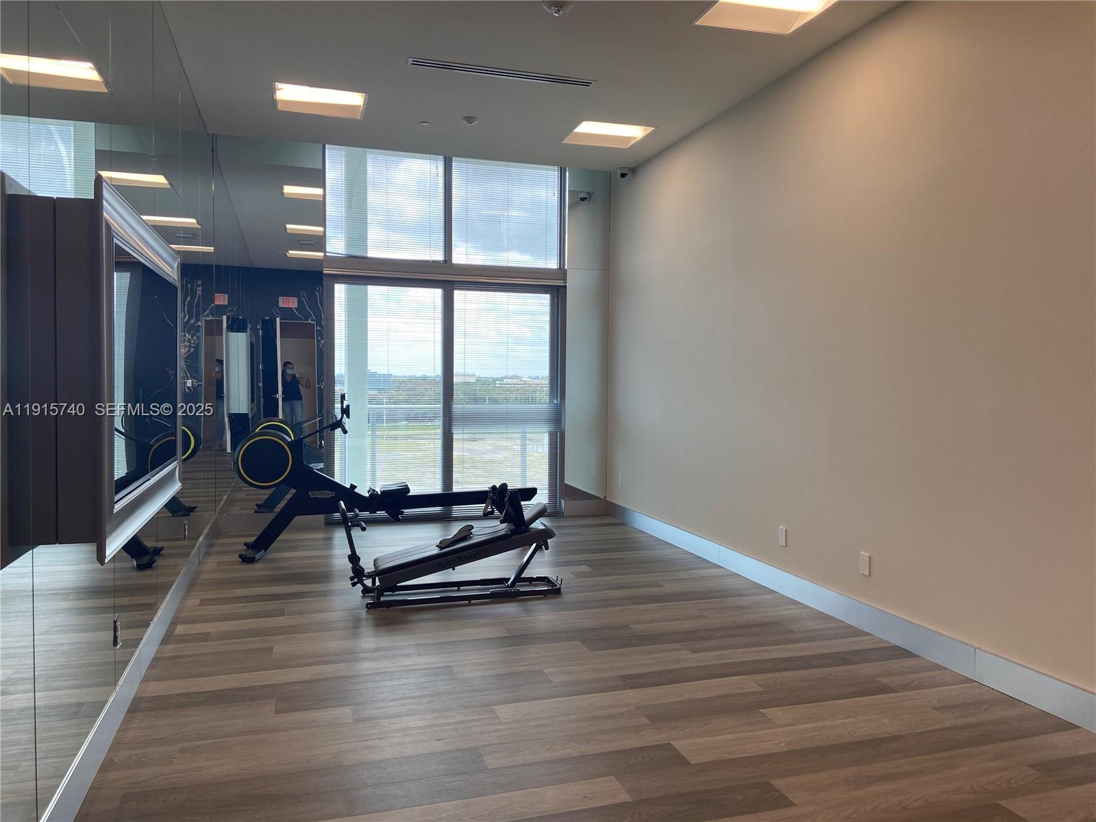 2000 Metropica Way, Unit 2104 Sunrise, FL 33323 - Photo 54 of 62 an empty room with floor to ceiling window and wooden floor