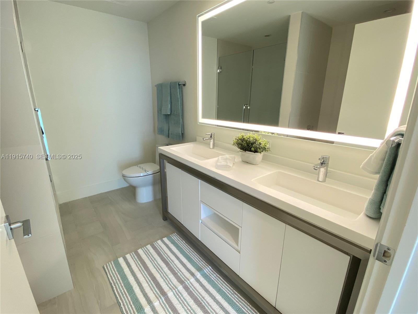 2000 Metropica Way, Unit 2104 Sunrise, FL 33323 - Photo 10 of 62 a bathroom with a sink and a mirror