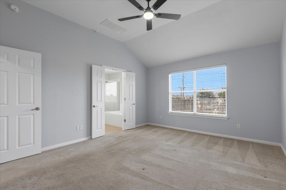 17812 Masi Loop Pflugerville, TX 78660 - Photo 20 of 38 Spacious room featuring vaulted ceilings, a ceiling fan with integrated lighting, and light gray wall finishes
