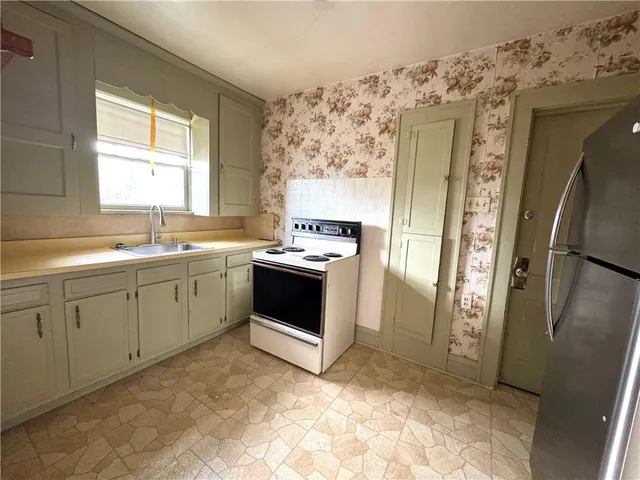 a kitchen with stainless steel appliances a stove a sink and a refrigerator