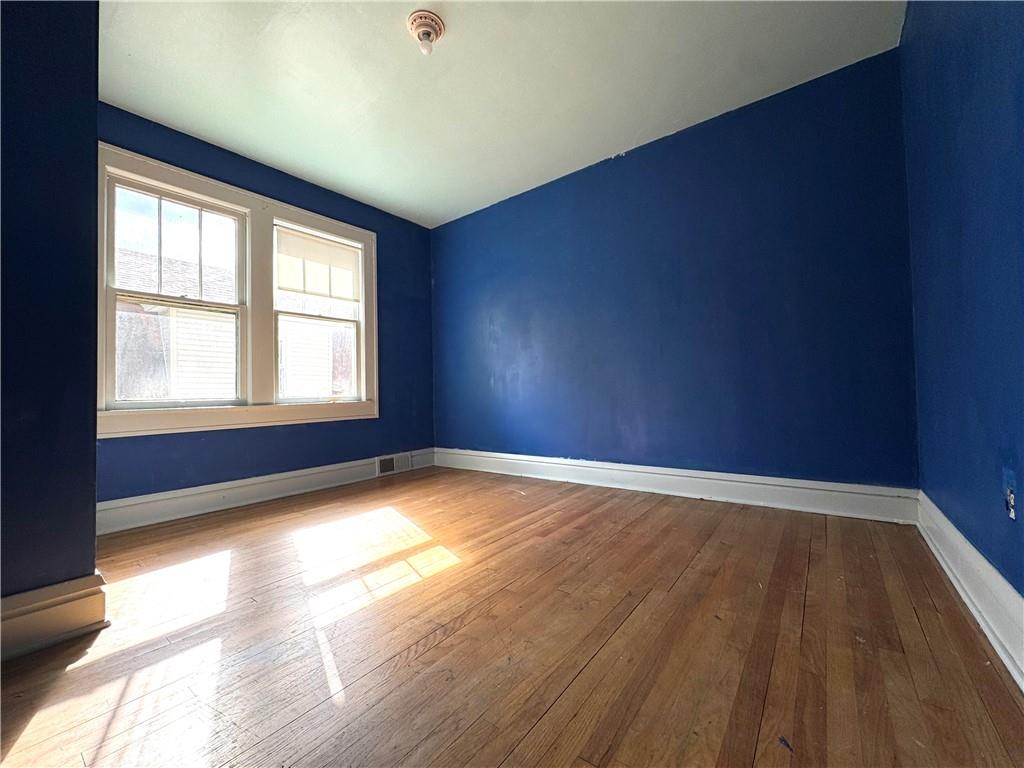 2212 Highland Avenue, Unit 2 New Castle, PA 16105 - Photo 7 of 9 an empty room with wooden floor and windows