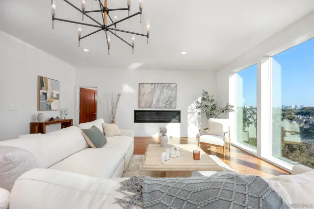 a living room with furniture a chandelier and a flat screen tv