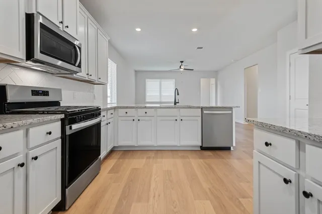 a kitchen with stainless steel appliances a stove microwave and cabinets